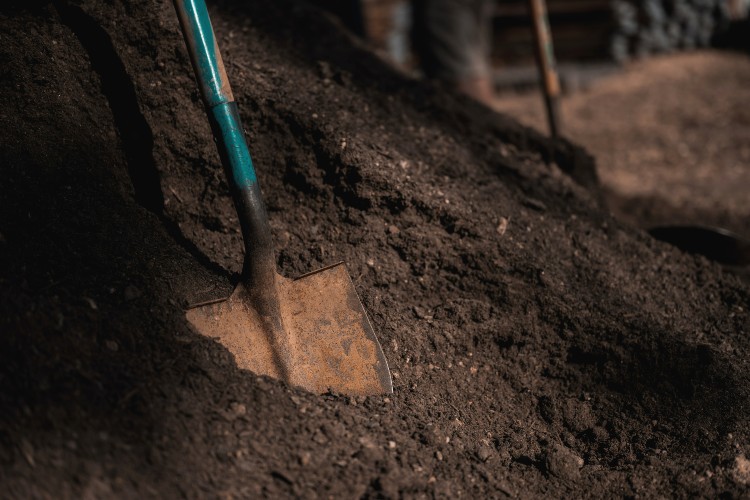 Pile of dirt with rusty shovel in it