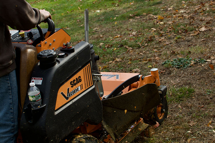 Yellow Sitting Lawnmower in the middle of a yard with freshly mowed green grass